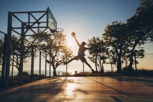 jeune-homme-faisant-du-sport-jouant-au-basket-ball-au-lever-du-soleil-sautant-silhouette