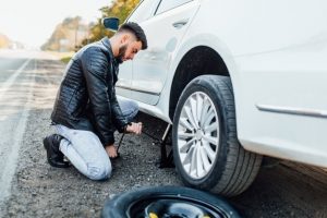 homme-barbu-changeant-pneu-sa-voiture